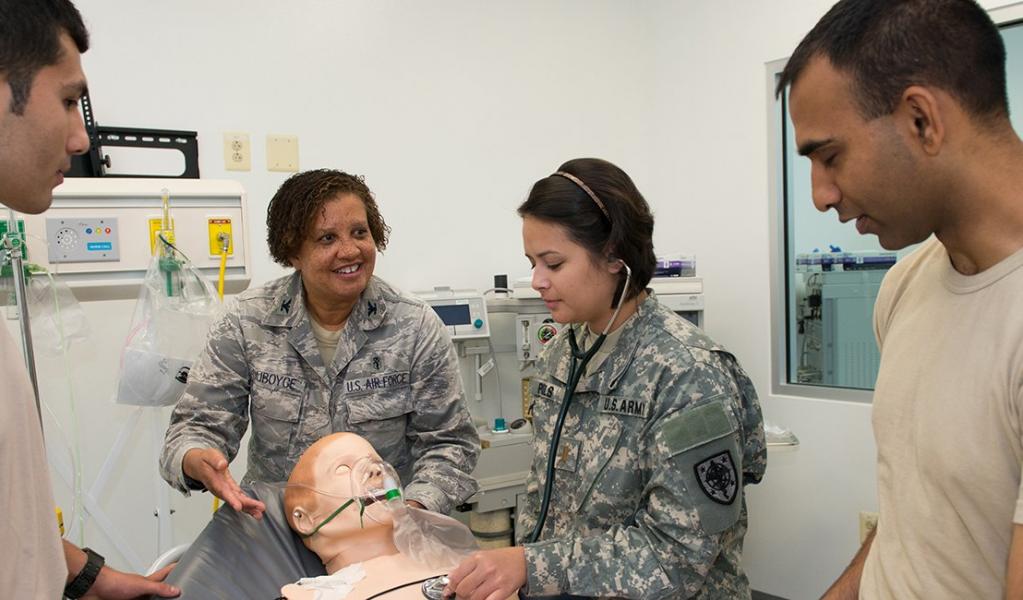 military medical students learn from professor using dummy