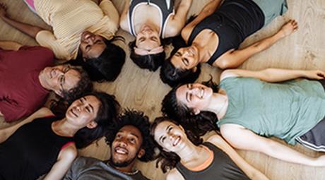 An overhead view of a group of people lying on their backs in a circle